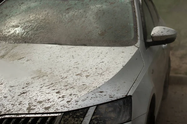 Dirty car on the street. Car wash. Pressurized water washes away dirt from vehicles.