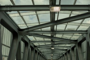 Tünelin tavanı demir kirişlerden yapılmıştır. Üst geçitin modern mimarisi. Metal yapı. Çelikten yapılmış üstten tünel.