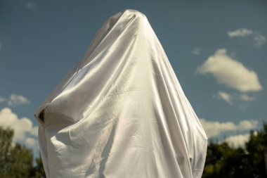 Beyaz kumaş figürü kaplıyor. Kültürel anıtın açılışı. Heykelin üzerindeki kutsal beyaz kumaş.