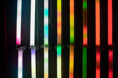 Renkli RGB lambaları. Karanlıktaki floresan lambaların tüm renklerinin parlaklığı.