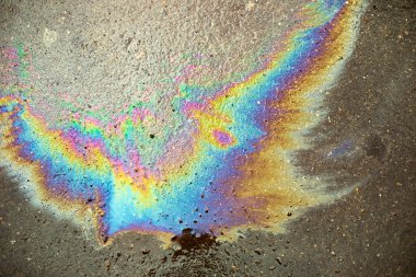 Asfaltta benzin lekesi var. Yakıt dokusu. Gökkuşağı yanıcı sıvı lekesi. Benzin birikintisi olan basit bir arkaplan.