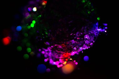 Renkli su dokusu. Farklı renklerde yanan su damlaları. Çeşmeden yakın plan su çekimi. Parlak renkler su akış arkaplanı.