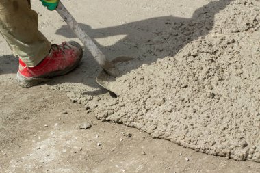 Yolda çimento var. Çimentoyu kürekle temizliyorum. İnşaat alanında inşaat çözeltisi. Kumdan yapılmış bir kirpi..