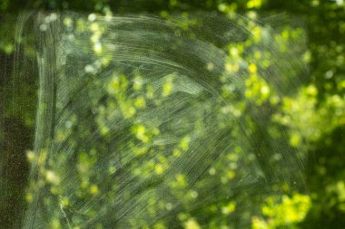 Kirli cam yüzey. Penceredeki tozun dokusu. Bulutlu camın arkasındaki manzara. Deterjanla yıkadıktan sonra camdaki lekeler. Ayrıntılı temizlik.