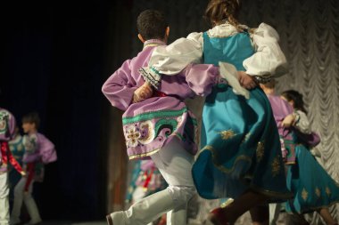 Halk kostümleriyle dans ediyorlar. Rus çocukları sarafanlarla dans ediyor. Dans grubunun performansı. Dans dersi. Çocuklar dansta koşar.