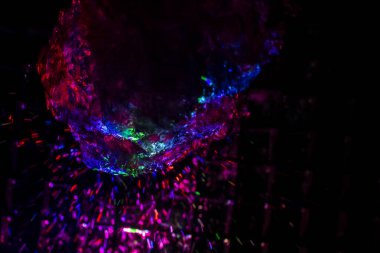 Renkli su dokusu. Farklı renklerde yanan su damlaları. Çeşmeden yakın plan su çekimi. Parlak renkler su akış arkaplanı.