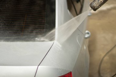 Araba yıkama. Araba bir su püskürtüsünün basıncıyla yıkanır. Arabanın yüzeyindeki kiri temizlemek için su spreyi kullanmışlar..