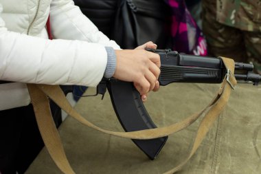 Kız otomatik ateşli bir silah dolduruyor. Silah kullanmada ders. Elin silahta olsun. Kadınların askeri eğitimi.