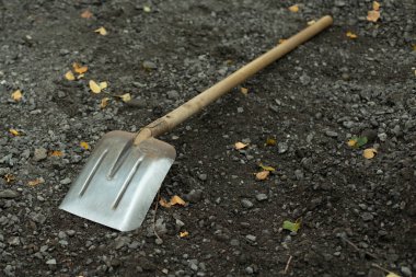 Kürek. Toptan malzemeler için inşa aleti. Kürek asfaltta yatıyor..