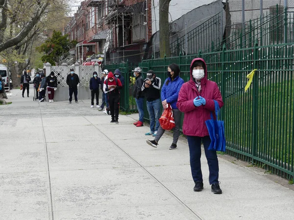 Brooklyn (EUA), 30 / 04 / 2020 - COVID-19 / FALTA de COMIDA - Bazı insanlar uzun bir kuyrukta durup yiyecek dağıtımının yapılmasını bekledi. Hükümet bu salgın sırasında tüm New Yorklulara günde 3 öğün yemek veriyor. 