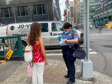 (Polis memurları Manhattan 'daki insanlara Facemaske dağıtırlar. 24 Haziran 2020, Manhattan, New York, ABD: New York Şehri yeniden açılmanın ikinci aşamasına girerken, bazı polis memurlarının 59. Cadde 'deki denizaltılardan birinin önünde halka Facemaske dağıttığı görülüyor.