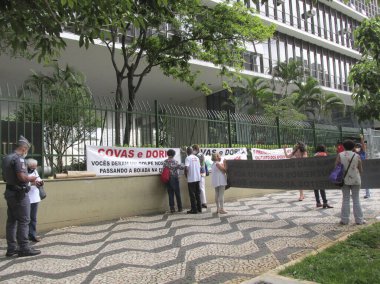 (Yeniden seçilen belediye başkanının ve meclis üyelerinin yemin töreni sırasında protesto. 1 Ocak 2021, Sao Paulo, Brezilya: Bir grup insan belediye binası önünde protesto düzenlerken, halk yemin sırasında evlerinden gözlemler yapıyor