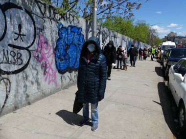 Brooklyn (EUA), 30 / 04 / 2020 - COVID-19 / FALTA de COMIDA - Bazı insanlar uzun bir kuyrukta durup yiyecek dağıtımının yapılmasını bekledi. Hükümet bu salgın sırasında tüm New Yorklulara günde 3 öğün yemek veriyor. 