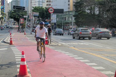 (Eğlence Döngüsü Yolları 'nın yeniden etkinleştirilmesi. 19 Temmuz 2020, Sao Paulo, Brezilya: Sao Paulo şehrindeki bisiklet yollarının yeniden etkinleştirilmesi, bu Pazar. Bisikletçiler maske takmıyor ve motosikletler arasında mesafeyi koruyorlar. . 