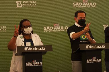  Sao Paulo Brezilya 'da Coronvac Aşısı Konferansı. 17 Ocak 2021, Sao Paulo, Brezilya: Sao Paulo Eyalet Valisi, Joao Doria Jr Brezilya 'da aşılanan ilk kişinin yanında, Monica Calazans, Lia Porto Eyalet Başsavcısı