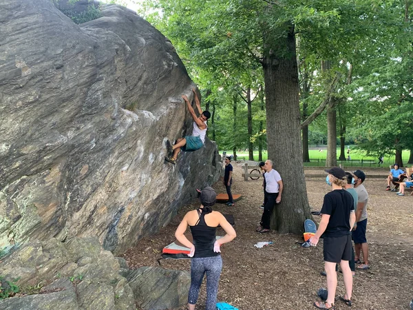セントラルパークでボルダリング 2020年7月16日ニューヨーク セントラルパークでボルダリングの練習をしている人もいます 岩のロープなしで登ると 安全マットの上に靴やチョークの袋を登ると バランスを使用して Teの岩です — ストック写真