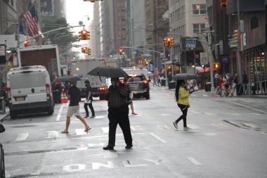 29 Eylül 2020, New York, ABD: Hafif bir yağış, New Yorkluları ve turistleri Coronavirus salgınının ortasında şemsiye ve yağmurluklarını kullanmaya zorluyor. Yağmur yağsa bile, insanlar Covid-19 'un yayılmasını önlemek için maske takıyor.