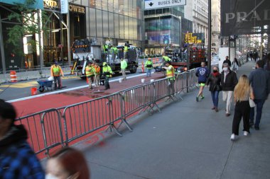 17 Ekim 2020, New York, ABD: İşçiler, New York 'taki Trump Tower' ın önündeki 57. caddede çakıl taşlarıyla yol yüzeyine çıkarken ve soğuk havada ağır araç ve yaya trafiğine yol açarken görüldü. (Fotoğraf: Niyi Fote / TheNews2 / Deposi