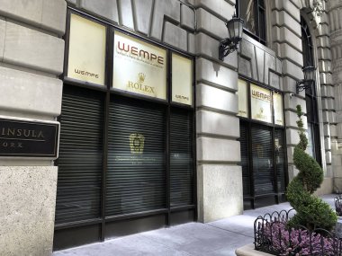 (Covid-19 'un ortasında lüks dükkanlar kapandı. 16 Nisan 2020, New York, ABD: New York 'ta Madison Bulvarı' ndaki lüks dükkanlar, Coronavirus salgını nedeniyle hırsızlığı önlemek için ahşap kaplama ve pencerelerle kapatıldı (covid- 19). İzolasyon ve ho kalmak