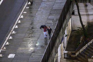 Sao Paulo 'da bulutlu hava ve yağış. 20 Ekim 2020, Sao Paulo, Brezilya: Sao Paulo 'da hava bulutlu ve sağanak yağış COVID-19 ile insanların şemsiye ve ceketlerini kullanmasını sağlıyor
