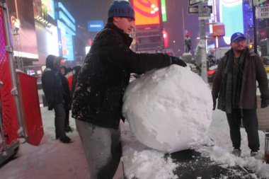 16 Aralık 2020, New York, ABD: Times Meydanı 'na yağan yoğun kara rağmen, birçok insan eğleniyor, kar taneleriyle oynuyor, kardan adam yapıyor, fotoğraf çekiyor. Ancak, karın artması ve ertesi güne kadar devam etmesi bekleniyor.