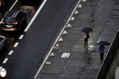 Sao Paulo 'da bulutlu hava ve yağış. 20 Ekim 2020, Sao Paulo, Brezilya: Sao Paulo 'da hava bulutlu ve sağanak yağış COVID-19 ile insanların şemsiye ve ceketlerini kullanmasını sağlıyor