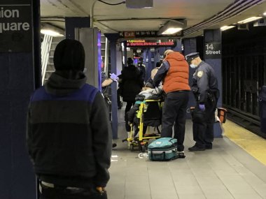 (Polisler, hasta bir adama ilk yardımı sağlıyorlar. 16 Nisan 2020, New York, ABD: New York 'ta 14. Union Square İstasyonu' nda hasta ve kötü hisseden bir adam, Koron salgını nedeniyle koruyucu maskeler takan polisler tarafından kurtarıldı.