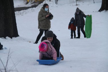 NOVA YORK (EUA), 05 / 02 / 2021 - MOVIMENTACAO CENTACAO PARK - Com a rescaldo da nevasca do dia anterior, nova-iorquinos e turistas sao vistos se divertindo se Central Park. Criancas fazendo snowboard, pessoas andando de carruagem, fazendo boneco de neve