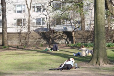 İnsanlar Paskalyayı Central Park 'ta kutluyor. 4 Nisan 2021, New York, ABD: İnsanlar sevdikleriyle Central Park 'ta Paskalya kutlaması yaparken, piknik yaparken, güneşli havanın keyfini çıkarırken, bisiklete binerken, patene binerken, scooterlara binerken, 
