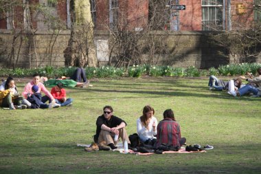 İnsanlar Paskalyayı Central Park 'ta kutluyor. 4 Nisan 2021, New York, ABD: İnsanlar sevdikleriyle Central Park 'ta Paskalya kutlaması yaparken, piknik yaparken, güneşli havanın keyfini çıkarırken, bisiklete binerken, patene binerken, scooterlara binerken, 