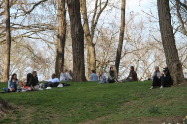 İnsanlar Paskalyayı Central Park 'ta kutluyor. 4 Nisan 2021, New York, ABD: İnsanlar sevdikleriyle Central Park 'ta Paskalya kutlaması yaparken, piknik yaparken, güneşli havanın keyfini çıkarırken, bisiklete binerken, patene binerken, scooterlara binerken, 