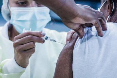 Sao Paulo 'da COVID-19' a karşı aşı. 16 Nisan 2021, Sao Paulo, Brezilya: UBS Cambuci 'de COVID-19' a karşı insanların aşılanması. Çin aşısının ikinci dozu CoronaVac ve AstraZeneca aşılar sırasında kullanıldı.