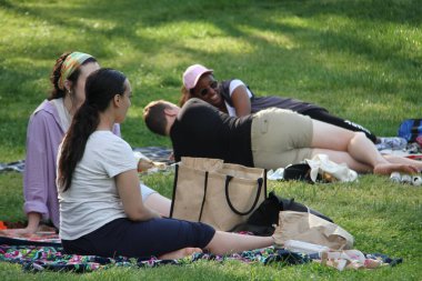 Covid-19 'un ortasında kalabalık bir Central Park. 15 Mayıs 2021, New York, ABD: Bu güneşli cumartesi Central Park 'ta COVID-19' un ortasında ağır bir hareket yaşandı. İnsanlar Central Park çimlerinde eğleniyor, piknik yapıyor, spor yapıyor ve müzik yapıyorlar. Çoğu 