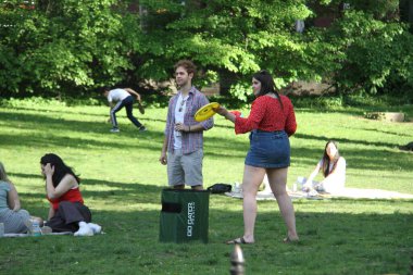 Covid-19 'un ortasında kalabalık bir Central Park. 15 Mayıs 2021, New York, ABD: Bu güneşli cumartesi Central Park 'ta COVID-19' un ortasında ağır bir hareket yaşandı. İnsanlar Central Park çimlerinde eğleniyor, piknik yapıyor, spor yapıyor ve müzik yapıyorlar. Çoğu 