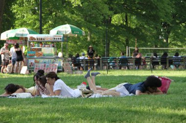 Covid-19 'un ortasında kalabalık bir Central Park. 15 Mayıs 2021, New York, ABD: Bu güneşli cumartesi Central Park 'ta COVID-19' un ortasında ağır bir hareket yaşandı. İnsanlar Central Park çimlerinde eğleniyor, piknik yapıyor, spor yapıyor ve müzik yapıyorlar. Çoğu 
