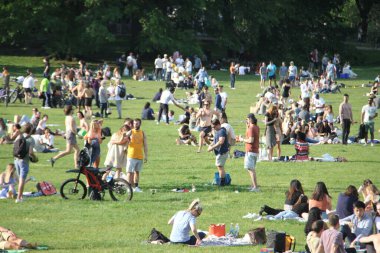 Covid-19 'un ortasında kalabalık bir Central Park. 15 Mayıs 2021, New York, ABD: Bu güneşli cumartesi Central Park 'ta COVID-19' un ortasında ağır bir hareket yaşandı. İnsanlar Central Park çimlerinde eğleniyor, piknik yapıyor, spor yapıyor ve müzik yapıyorlar. Çoğu 