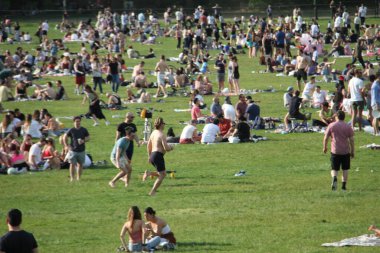 Covid-19 'un ortasında kalabalık bir Central Park. 15 Mayıs 2021, New York, ABD: Bu güneşli cumartesi Central Park 'ta COVID-19' un ortasında ağır bir hareket yaşandı. İnsanlar Central Park çimlerinde eğleniyor, piknik yapıyor, spor yapıyor ve müzik yapıyorlar. Çoğu 