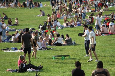 Covid-19 'un ortasında kalabalık bir Central Park. 15 Mayıs 2021, New York, ABD: Bu güneşli cumartesi Central Park 'ta COVID-19' un ortasında ağır bir hareket yaşandı. İnsanlar Central Park çimlerinde eğleniyor, piknik yapıyor, spor yapıyor ve müzik yapıyorlar. Çoğu 