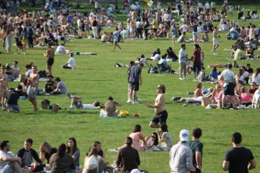 Covid-19 'un ortasında kalabalık bir Central Park. 15 Mayıs 2021, New York, ABD: Bu güneşli cumartesi Central Park 'ta COVID-19' un ortasında ağır bir hareket yaşandı. İnsanlar Central Park çimlerinde eğleniyor, piknik yapıyor, spor yapıyor ve müzik yapıyorlar. Çoğu 