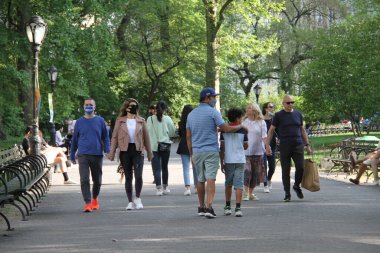 Covid-19 'un ortasında kalabalık bir Central Park. 15 Mayıs 2021, New York, ABD: Bu güneşli cumartesi Central Park 'ta COVID-19' un ortasında ağır bir hareket yaşandı. İnsanlar Central Park çimlerinde eğleniyor, piknik yapıyor, spor yapıyor ve müzik yapıyorlar. Çoğu 