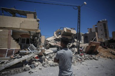 İsrailliler ve Filistinliler arasındaki çatışma yoğunlaşır; 16 Mayıs 2021: Gazze Şeridi, Filistin Toprakları: Filistinliler, Gazze Şeridi 'nin güneyindeki Han Yunus' ta İsrail hava saldırıları sonucu yıkılan bir evin enkazını teftiş ederler. 