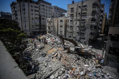 Gazze 'deki bombalama kurbanlarını arıyor. 17 Mayıs 2021, Gazze, Filistin: 17 Mayıs 2021 - Gazze: Filistinliler, büyük İsrail 'in El-Rimal semtindeki yıkılmış bir binanın yıkıntıları altında mağdurları arıyorlar 