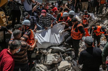 Gazze 'deki bombalama kurbanlarını arıyor. 17 Mayıs 2021, Gazze, Filistin: 17 Mayıs 2021 - Gazze: Filistinliler, büyük İsrail 'in El-Rimal semtindeki yıkılmış bir binanın yıkıntıları altında mağdurları arıyorlar 