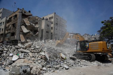 Gazze 'deki bombalama kurbanlarını arıyor. 17 Mayıs 2021, Gazze, Filistin: 17 Mayıs 2021 - Gazze: Filistinliler, büyük İsrail 'in El-Rimal semtindeki yıkılmış bir binanın yıkıntıları altında mağdurları arıyorlar 