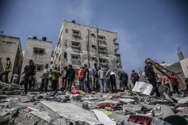 Gazze 'deki bombalama kurbanlarını arıyor. 17 Mayıs 2021, Gazze, Filistin: 17 Mayıs 2021 - Gazze: Filistinliler, büyük İsrail 'in El-Rimal semtindeki yıkılmış bir binanın yıkıntıları altında mağdurları arıyorlar 