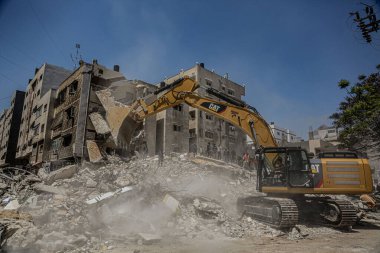 Gazze 'deki bombalama kurbanlarını arıyor. 17 Mayıs 2021, Gazze, Filistin: 17 Mayıs 2021 - Gazze: Filistinliler, büyük İsrail 'in El-Rimal semtindeki yıkılmış bir binanın yıkıntıları altında mağdurları arıyorlar 