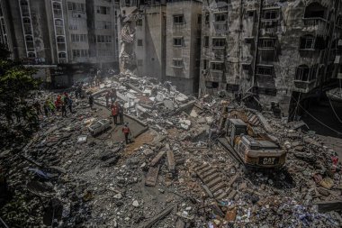 Gazze 'deki bombalama kurbanlarını arıyor. 17 Mayıs 2021, Gazze, Filistin: 17 Mayıs 2021 - Gazze: Filistinliler, büyük İsrail 'in El-Rimal semtindeki yıkılmış bir binanın yıkıntıları altında mağdurları arıyorlar 