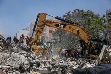 Gazze 'deki bombalama kurbanlarını arıyor. 17 Mayıs 2021, Gazze, Filistin: 17 Mayıs 2021 - Gazze: Filistinliler, büyük İsrail 'in El-Rimal semtindeki yıkılmış bir binanın yıkıntıları altında mağdurları arıyorlar 