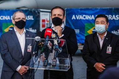 Sao Paulo. 25 Mayıs 2021 - Korona aşısı üretimi için girişlerin gelişi. Brezilya: Sao Paulo Valisi Joao Doria ve Sağlık Bakanı Jean Gorinchteyn, 3.000 litre Active Pharmace 'ın inişine eşlik ediyorlar  