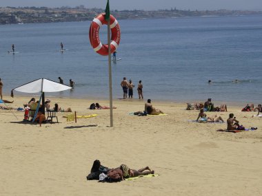 Portekiz 'deki Ribeira plajında banyo hareketleri. 26 Mayıs 2021, Cascais, Portekiz: Banyo güneşli bir günün tadını çıkarıyor Ribeira sahilinde, Cascais, Lizbon bölgesinin merkezinde, bu bahar çarşamba